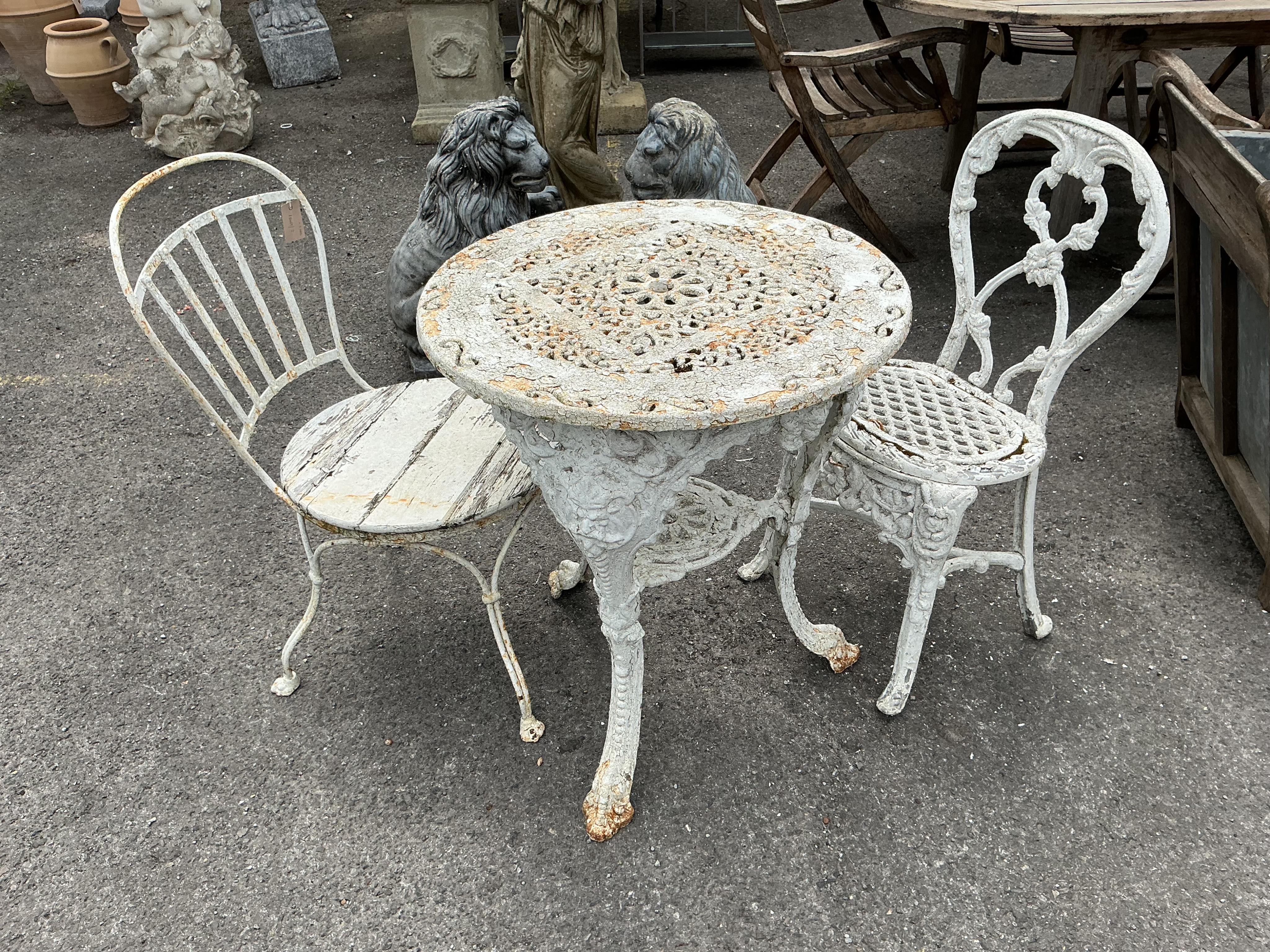 A Victorian Coalbrookdale style later painted circular cast iron garden table, diameter 61cm, height 70cm together with two later chairs